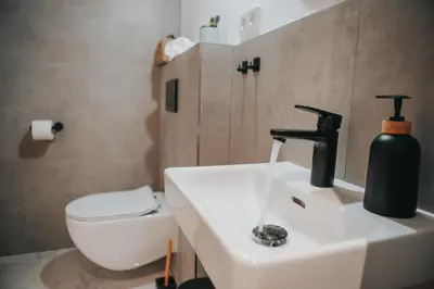 a bathroom with a sink with a black soap dispenser on it at Zizkoff apartments in Prague