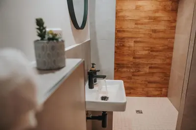 a bathroom with a white sink and a wooden wall at Zizkoff apartments in Prague
