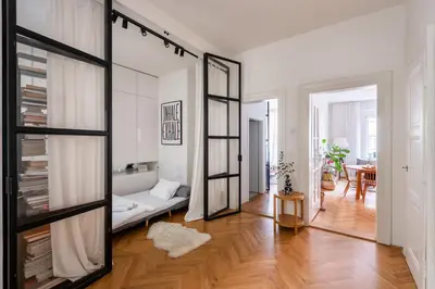 a living room with a couch and a mirror at Gallery Apartment in Prague