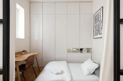 a small bedroom with a bed and a desk at Gallery Apartment in Prague
