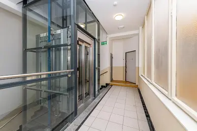 an empty hallway in a building with glass doors at Top Floor Industrial Apartment with a River View in Prague