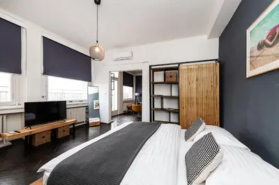a bedroom with a bed and a flat screen tv at Top Floor Industrial Apartment with a River View in Prague