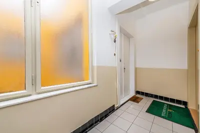 a bathroom with a window and a green rug on the floor at Top Floor Industrial Apartment with a River View in Prague