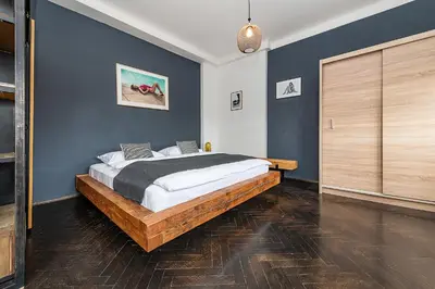 a bedroom with a large bed and blue walls at Top Floor Industrial Apartment with a River View in Prague