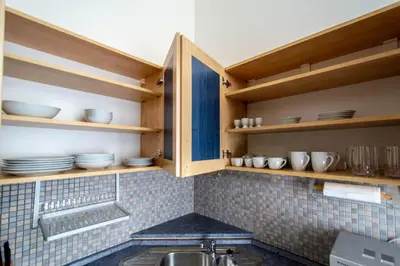 a kitchen with wooden shelves and a sink at Jewish Synagogue Ruterra Suite in Prague