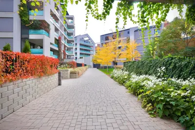 a walkway in a city with buildings and flowers at Modern Apartment • Garden • Near The City Center in Prague