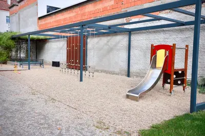 a playground with a slide in front of a building at Modern Apartment • Garden • Near The City Center in Prague