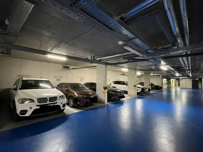 a garage with several cars parked in it at Modern Apartment • Garden • Near The City Center in Prague