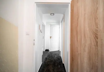 a hallway with white walls and a white door at Secret Budget Studio Oasis in Prague