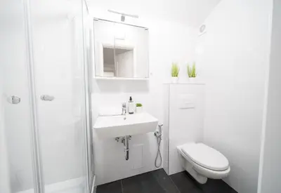 a white bathroom with a toilet and a sink at Secret Budget Studio Oasis in Prague