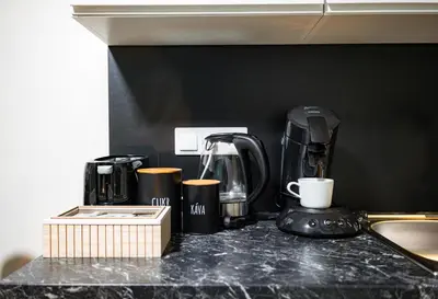 a counter with a coffee maker and cups on it at Secret Budget Studio Oasis in Prague