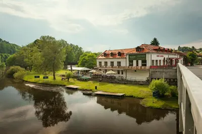 a building sitting on the side of a river at Ubytování Ostende - penzion in Chocerady
