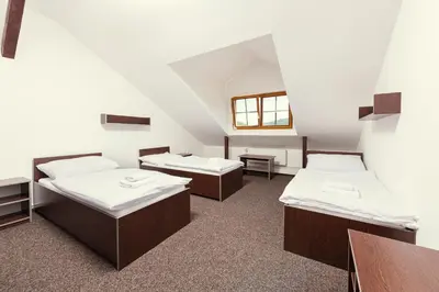 a room with three beds and a table at Ubytování Ostende - penzion in Chocerady