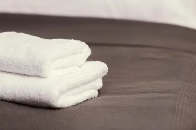 a stack of white towels sitting on a bed at Ubytování Ostende - penzion in Chocerady