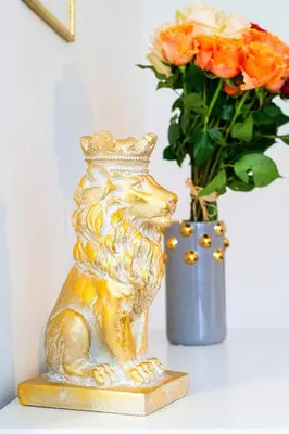 a gold lion statue next to a vase with flowers at Brilliant Deluxe Suite in Prague