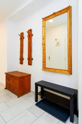 a mirror on a wall with a bench and a table at Brilliant Deluxe Suite in Prague