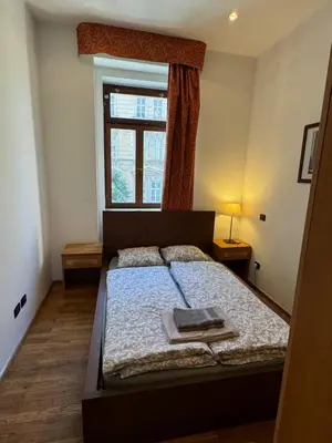 a bedroom with a bed with a book on it at Vitkova apartment with balcony in Prague