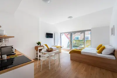 a small room with a bed and a kitchen at Libero Apartments in Prague