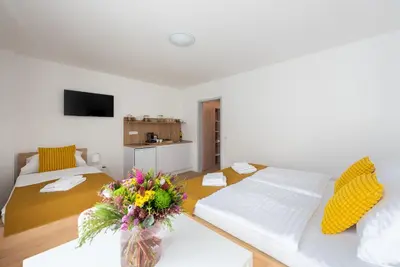 a living room with two beds and a vase of flowers at Libero Apartments in Prague