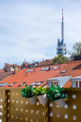 a view of roofs from a fence with plants at Libero Apartments in Prague