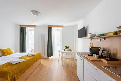 a bedroom with a large bed and a kitchen at Libero Apartments in Prague