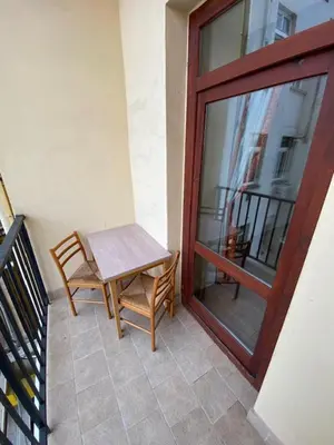 a table and chair on a balcony with a sliding glass door at 1 Bed Flat - Sleeps 2 - Pets - Smoking on terrace in Prague