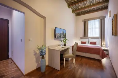 a bedroom with a bed and a desk and a table at Boutique Residence by Little King in Prague