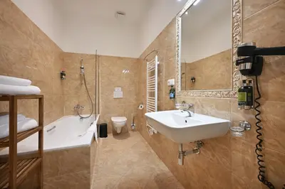 a bathroom with a sink and a tub and a toilet at Boutique Residence by Little King in Prague