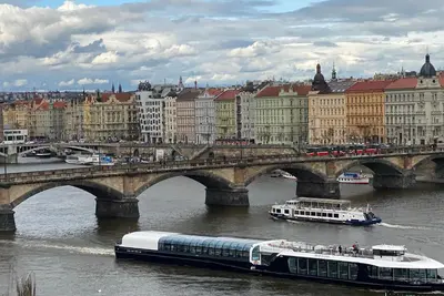 a bridge over a river with buildings and a bus at Spectacular Prague Views room for 1 or 2 in Prague