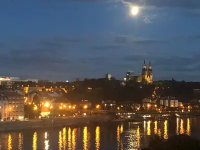 a view of a city at night with the moon at Spectacular Prague Views room for 1 or 2 in Prague