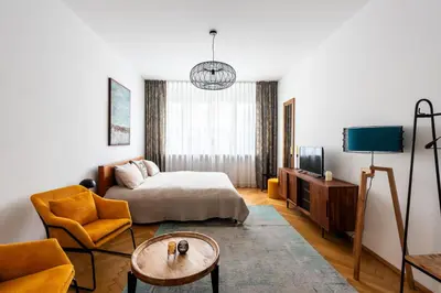 a bedroom with a bed and a couch and a table at Family Flat Bartolomejska in Prague