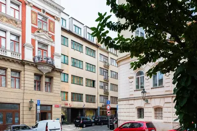 a large building with cars parked in front of it at Family Flat Bartolomejska in Prague