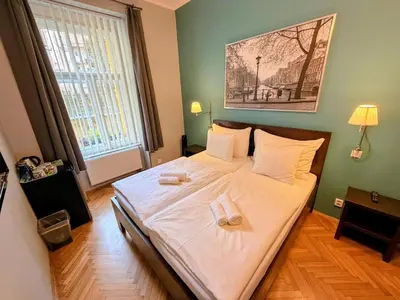 a bedroom with a large bed with a red wall at Central Station Studios in Prague