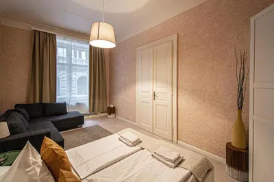 a bedroom with a bed and a couch in a room at Rose Ruterra Suite in Prague