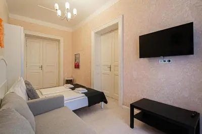 a living room with a couch and a tv on the wall at Rose Ruterra Suite in Prague