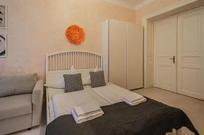 a small bedroom with a bed and a couch at Rose Ruterra Suite in Prague