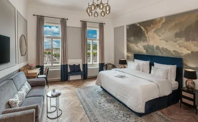 a bedroom with a large bed and a couch at River Dance Suites by Adrez in Prague