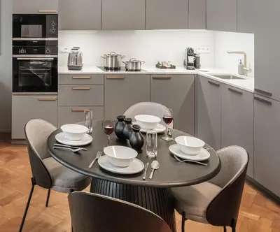 a kitchen with a table with chairs and wine glasses at River Dance Suites by Adrez in Prague