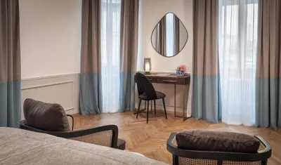 a bedroom with a bed and a desk and a mirror at River Dance Suites by Adrez in Prague