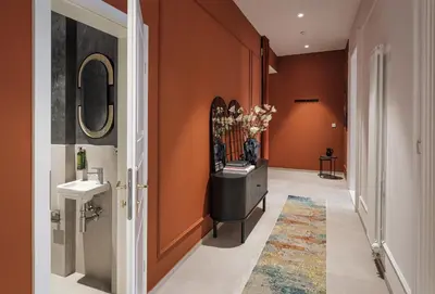 a hallway with a bathroom with orange walls at River Dance Suites by Adrez in Prague