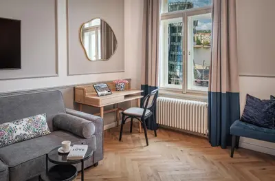 a living room with a couch and a table and a window at River Dance Suites by Adrez in Prague