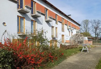 a white building with orange and blue windows and flowers at Centrum Mariapoli in Prague