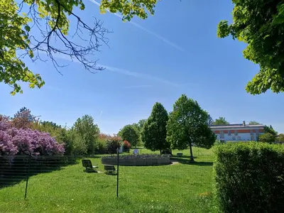 a park with benches and trees and a building at Centrum Mariapoli in Prague