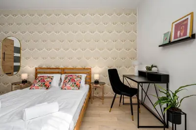 a bedroom with a bed and a desk with a chair at Art Deco Suite in Prague