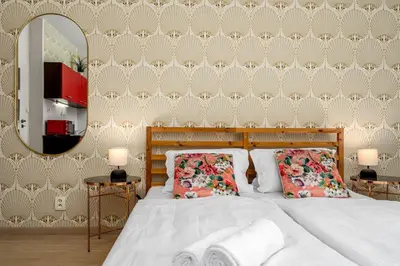 a bedroom with a bed with two pillows and a mirror at Art Deco Suite in Prague