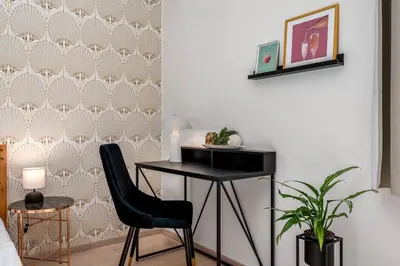 a room with a desk and a chair and a wall at Art Deco Suite in Prague