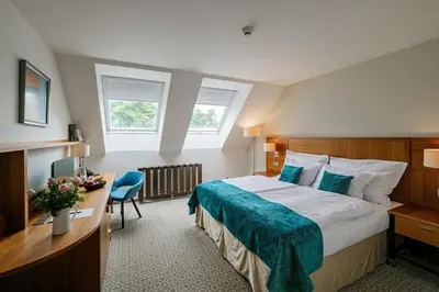a hotel room with a bed and a desk at Hotel Silenzio in Prague