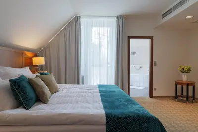 a bedroom with a large bed and a bathroom at Hotel Silenzio in Prague