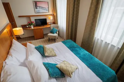 a hotel room with a bed with blue pillows at Hotel Silenzio in Prague