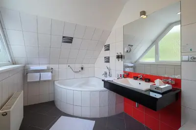 a white bathroom with a tub and a sink at Hotel Silenzio in Prague